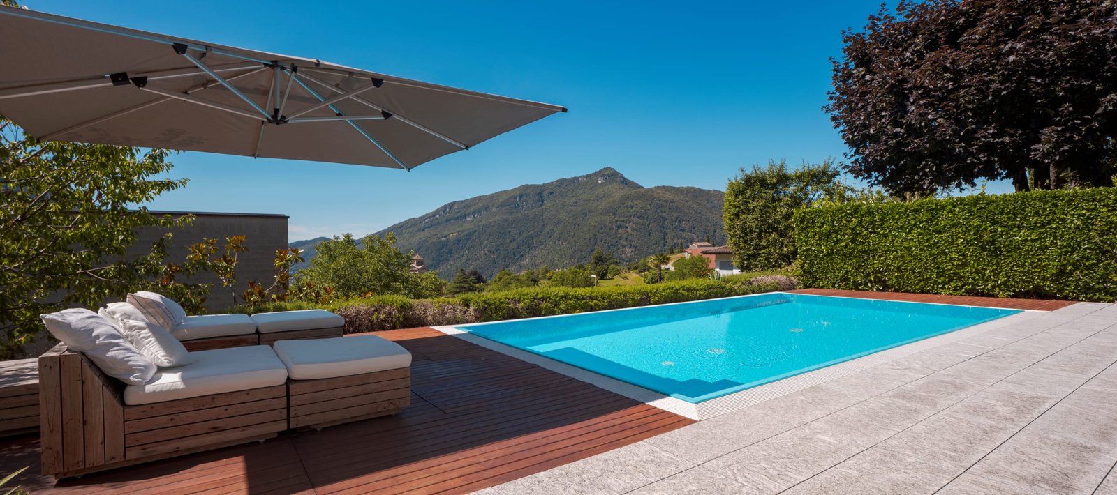 Large modern pool with two sun loungers for sunbathing and an op